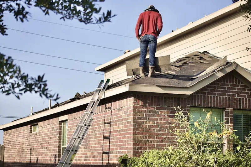 Professional roofer working on a residential roof in Roulo